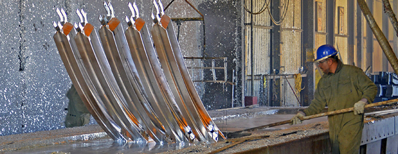 Steel poles being hot-dip galvanized in a molten zinc bath
